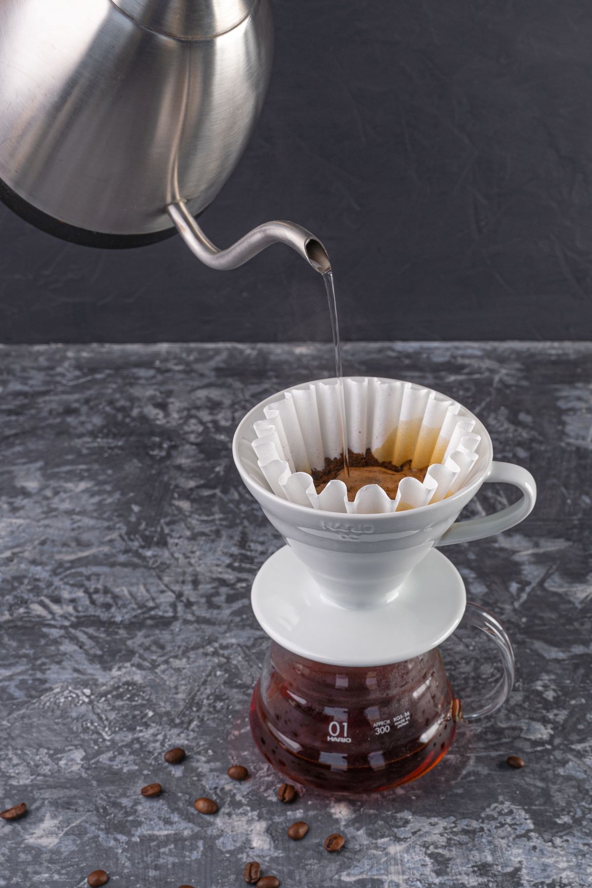 การเทน้ำจากกาคอห่านลงบนกาแฟดริป